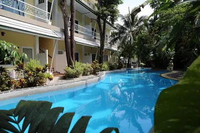 a large blue swimming pool next to a building at Naka Resort in Kamala Beach