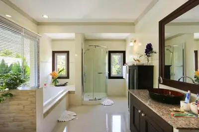 a bathroom with a tub and a shower and a sink at Naka Resort in Kamala Beach