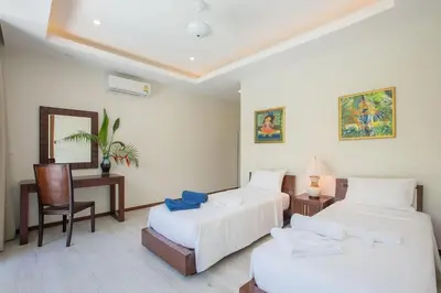 a bedroom with two beds and a desk and a chair at VILLA Bangka 4BR Private pool villa Rawai in Rawai Beach