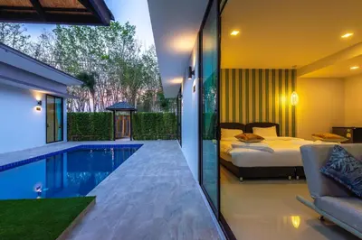 a bedroom with a bed and a swimming pool at Lespalm Taraburi Pool Villa SHA Plus in Thalang