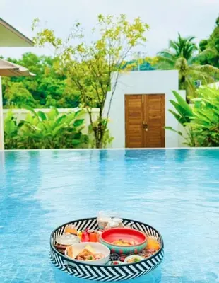 a tray of food sitting on top of a swimming pool at Lespalm Taraburi Pool Villa SHA Plus in Thalang
