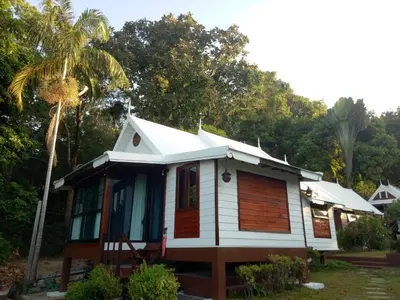 a white house with a palm tree in front of it at Le Passe-Temps in Tha Lane Bay