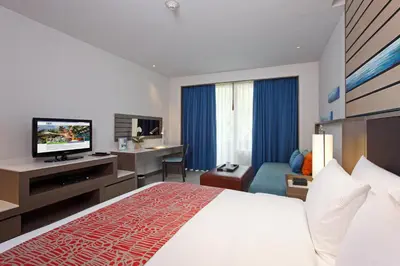 a hotel room with a bed and a flat screen tv at Holiday Inn Resort Phuket, an IHG Hotel in Patong Beach