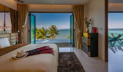 a bedroom with a bed with a view of the ocean at Saengsuree Villas Koh Yao Yai in Ko Yao Yai
