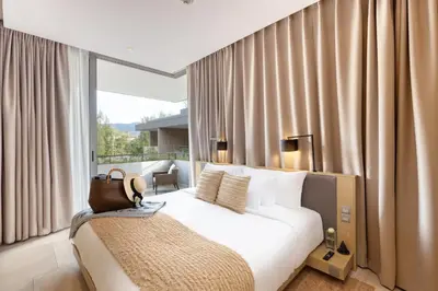 a bedroom with a white bed and a window with curtains at Twinpalms MontAzure Phuket in Kamala Beach