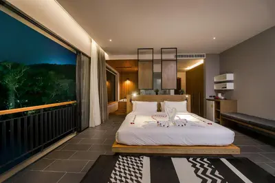 a bedroom with a large bed and a balcony at The Gallery Hotel Nai Harn in Nai Harn Beach