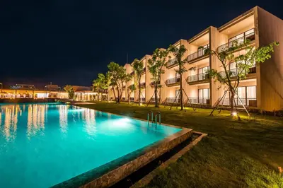 a swimming pool in front of a building at night at The Gallery Hotel Nai Harn in Nai Harn Beach