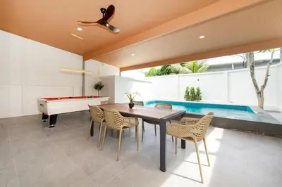 a dining room with a ping pong table and a pool at Prime Patong-5BR-6BR pool villa See photo BEFORE BOOK in Patong Beach