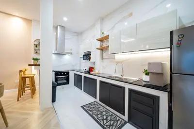 a kitchen with white cabinets and a black refrigerator at Prime Patong-5BR-6BR pool villa See photo BEFORE BOOK in Patong Beach