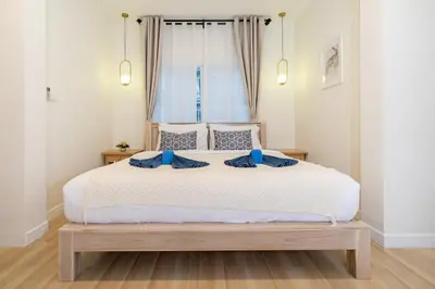 a bedroom with a large white bed with blue pillows at Prime Patong-5BR-6BR pool villa See photo BEFORE BOOK in Patong Beach