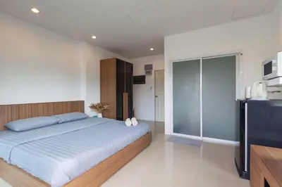 a bedroom with a large bed and a television at Number 4 Phuket in Nai Harn Beach