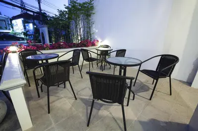 a group of tables and chairs on a patio at Number 4 Phuket in Nai Harn Beach