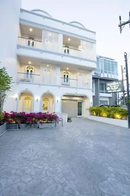 a white building with a bench in front of it at Number 4 Phuket in Nai Harn Beach