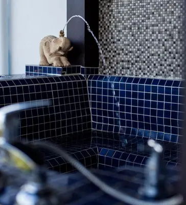 a bathroom with a gargoyle sitting on a blue tile counter at Number 4 Phuket in Nai Harn Beach