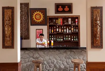 a man standing behind a bar with a drink at Seeka Boutique Resort in Patong Beach