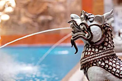 a statue of a dragon drinking water from a pool at Seeka Boutique Resort in Patong Beach