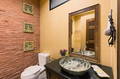 a bathroom with a sink and a toilet and a mirror at Seeka Boutique Resort in Patong Beach
