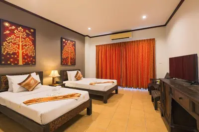a hotel room with two beds and a flat screen tv at Seeka Boutique Resort in Patong Beach
