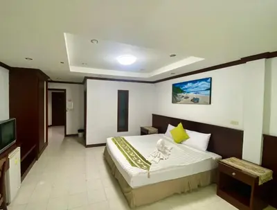 a bedroom with a large bed and a television at Sue@Cozy Guesthouse in Kata Beach