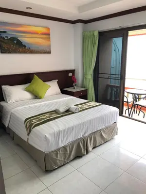 a bedroom with a large bed with a balcony at Sue@Cozy Guesthouse in Kata Beach