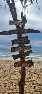 a sign on the beach with many signs at Sue@Cozy Guesthouse in Kata Beach