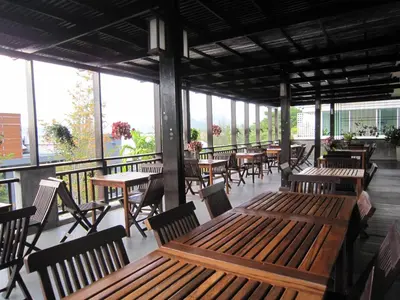 a restaurant with wooden tables and chairs and windows at Royal Nakara Ao Nang in Ao Nang Beach