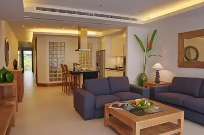 a living room with two blue couches and a table at Pearl of Naithon in Nai Thon Beach