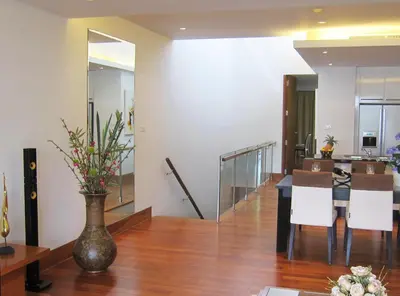 a living room with a table and a vase with flowers at Pearl of Naithon in Nai Thon Beach