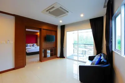 a living room with a couch and a bedroom at Sungthong Kamala Beach Resort in Kamala Beach
