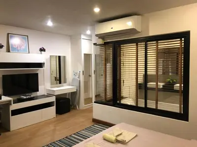 a living room with a large window and a television at WOW Apartment at Unity Patong in Patong Beach