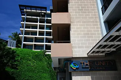 a building with a sign in front of a building at WOW Apartment at Unity Patong in Patong Beach