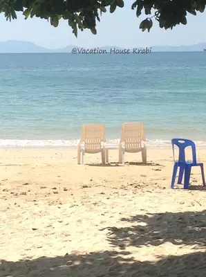 two chairs and a table on the beach at Vacation House in Klong Muang Beach