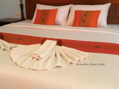a bedroom with two beds with white sheets and orange pillows at Vacation House in Klong Muang Beach