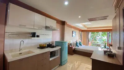 a kitchen with a sink and a room with a bed at Baan Kongdee Sunset Resort Kata in Kata Beach