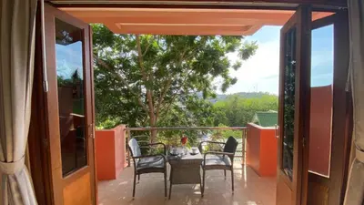 a patio with a table and chairs on a balcony at Baan Kongdee Sunset Resort Kata in Kata Beach