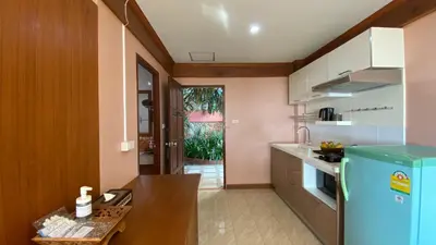 a kitchen with a blue refrigerator and a table at Baan Kongdee Sunset Resort Kata in Kata Beach