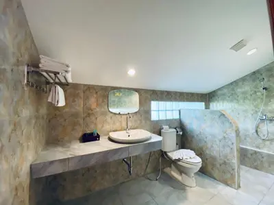 a bathroom with a sink and a toilet and a shower at Aochalong Villa Resort & Spa - SHA Plus in Chalong