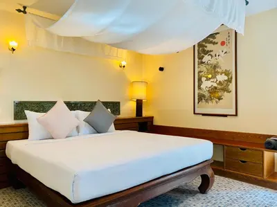 a bedroom with a large bed with white sheets at Aochalong Villa Resort & Spa - SHA Plus in Chalong