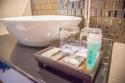 a tray with two glass containers on a counter with a sink at Aochalong Villa Resort & Spa - SHA Plus in Chalong