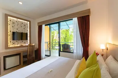 a bedroom with a bed and a large window at Aochalong Villa Resort & Spa - SHA Plus in Chalong