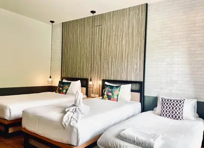 a room with two beds and a couch at PP GRAND KAMALA HOTEL-SHA Extra Plus in Kamala Beach