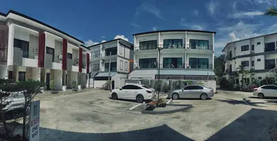 two cars parked in a parking lot in front of a building at PP GRAND KAMALA HOTEL-SHA Extra Plus in Kamala Beach