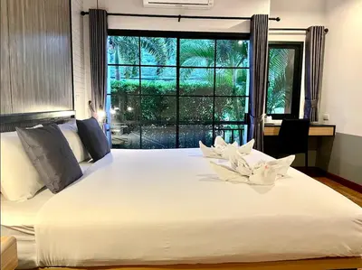 a bedroom with a large white bed with a window at PP GRAND KAMALA HOTEL-SHA Extra Plus in Kamala Beach