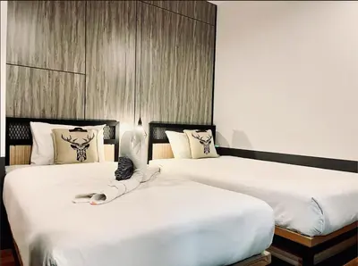 two beds sitting next to each other in a room at PP GRAND KAMALA HOTEL-SHA Extra Plus in Kamala Beach