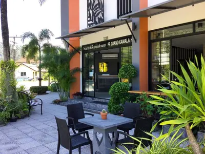 a patio with chairs and a table in front of a building at PP GRAND KAMALA HOTEL-SHA Extra Plus in Kamala Beach