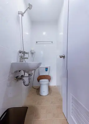 a white bathroom with a toilet and a sink at Silla Patong Boutique - Beach Walk Access in Patong Beach