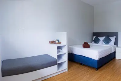 a small bedroom with two beds and a shelf at Silla Patong Boutique - Beach Walk Access in Patong Beach
