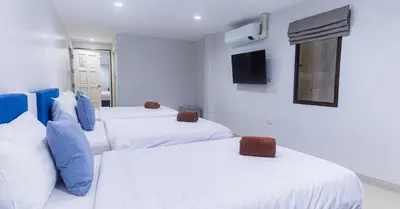 a room with three beds and a tv on the wall at Silla Patong Boutique - Beach Walk Access in Patong Beach