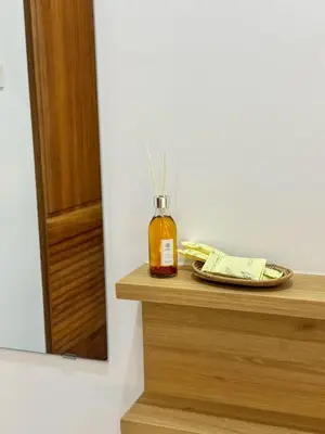 a bottle of honey sitting on a counter next to a mirror at Baan Trok Bedroom Studio Maikhao in Mai Khao Beach