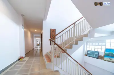 a staircase in a house with white walls and wooden stairs at Ming Shou Boutique House in Phuket Town